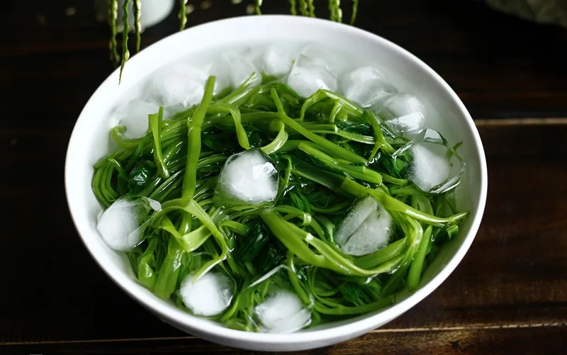 Tuyệt chiêu vớt rau muống thả ngay vào thau nước đá lạnh để khóa chặt độ giòn sần sật.